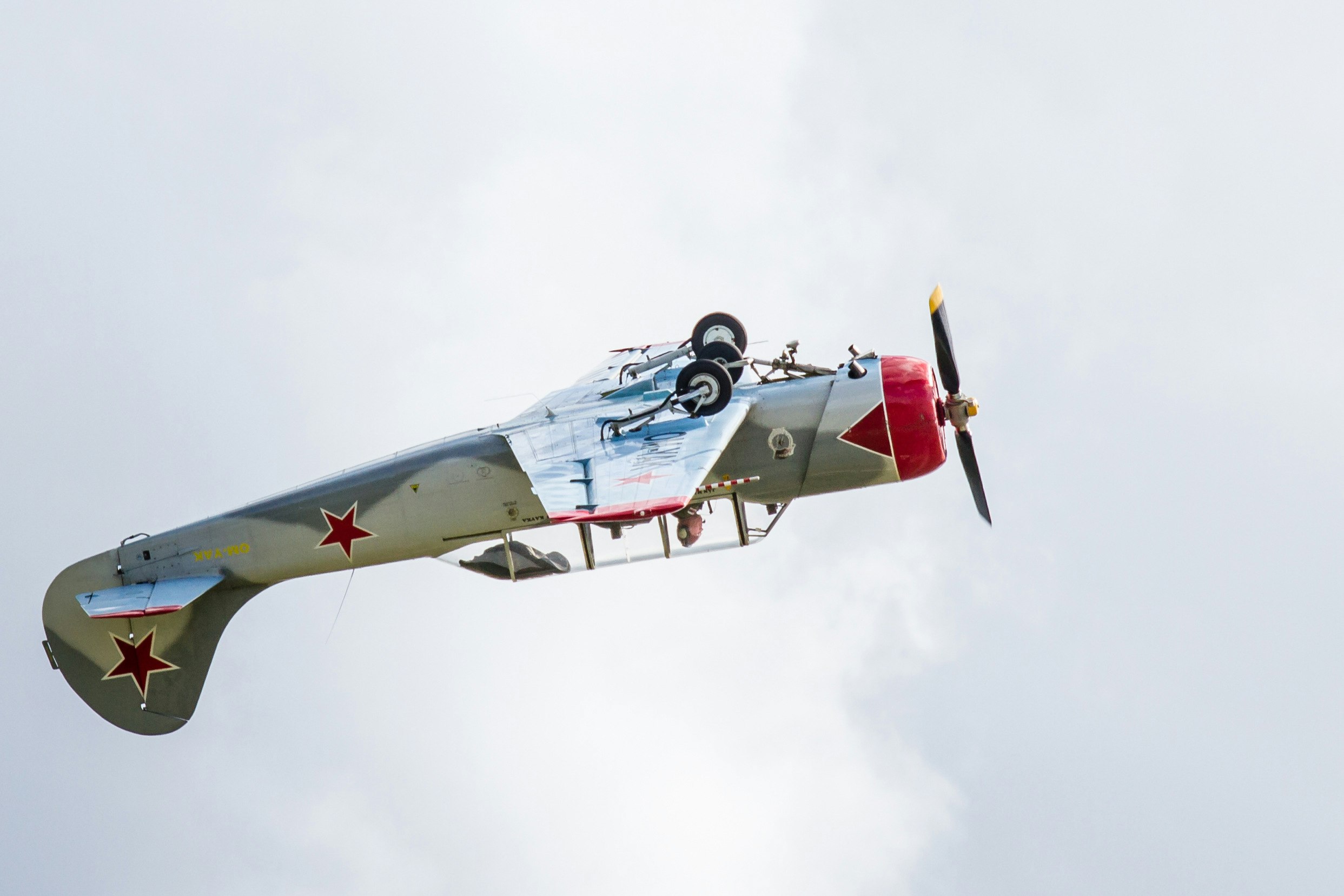 gray and red airplane making a stunt